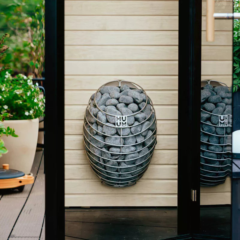 HUUM Drop 9kW electric sauna heater with Wi-Fi app control shown in a light wood sauna