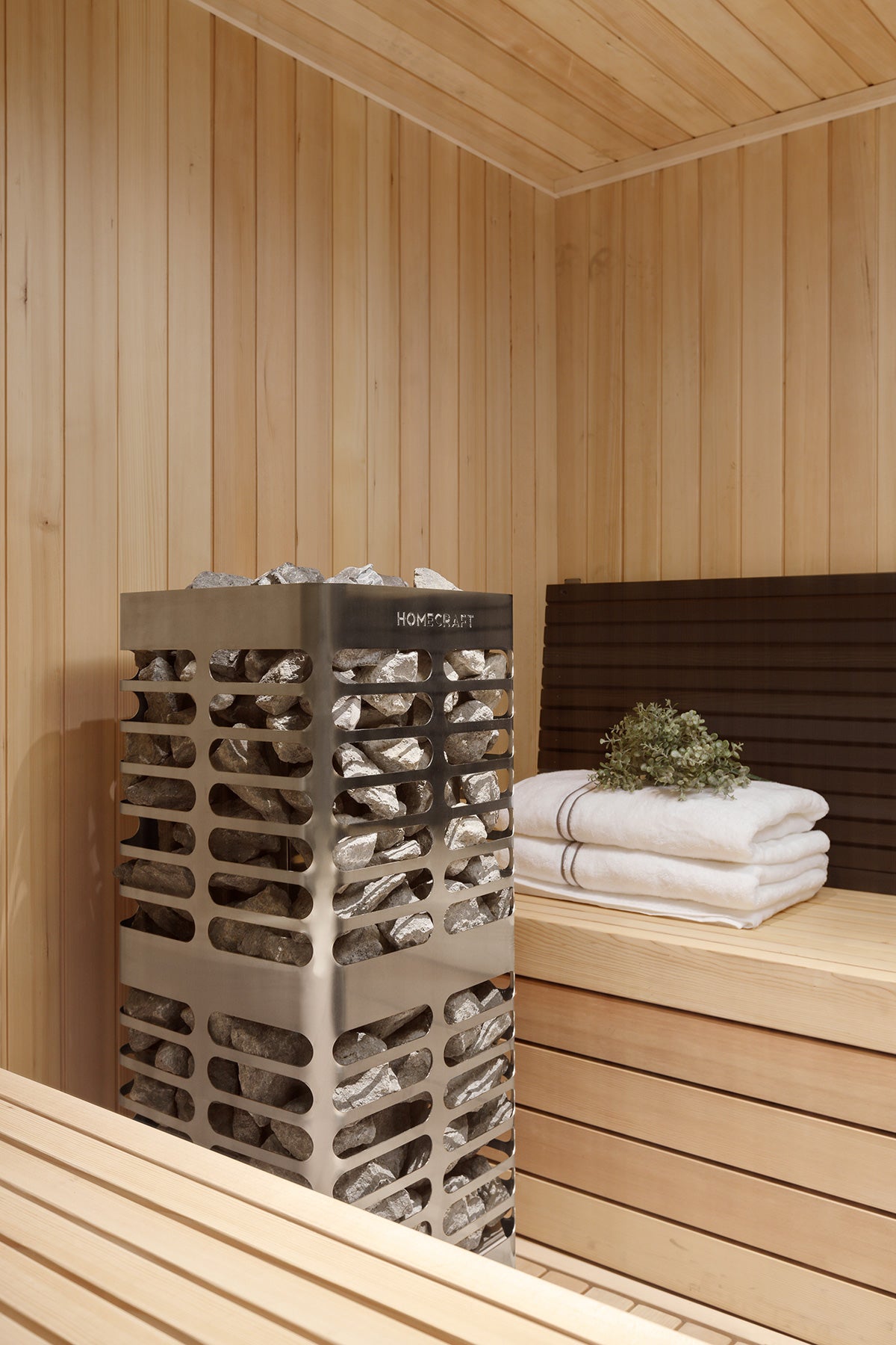 Homecraft Revive sauna heater in a cedar corner beside folded towels