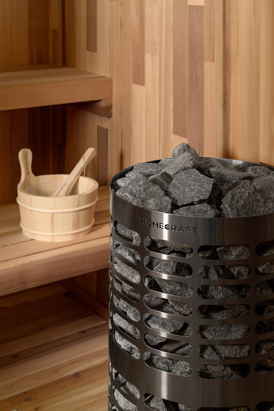 Homecraft Apex sauna heater in a cedar sauna with a wooden bucket and ladle