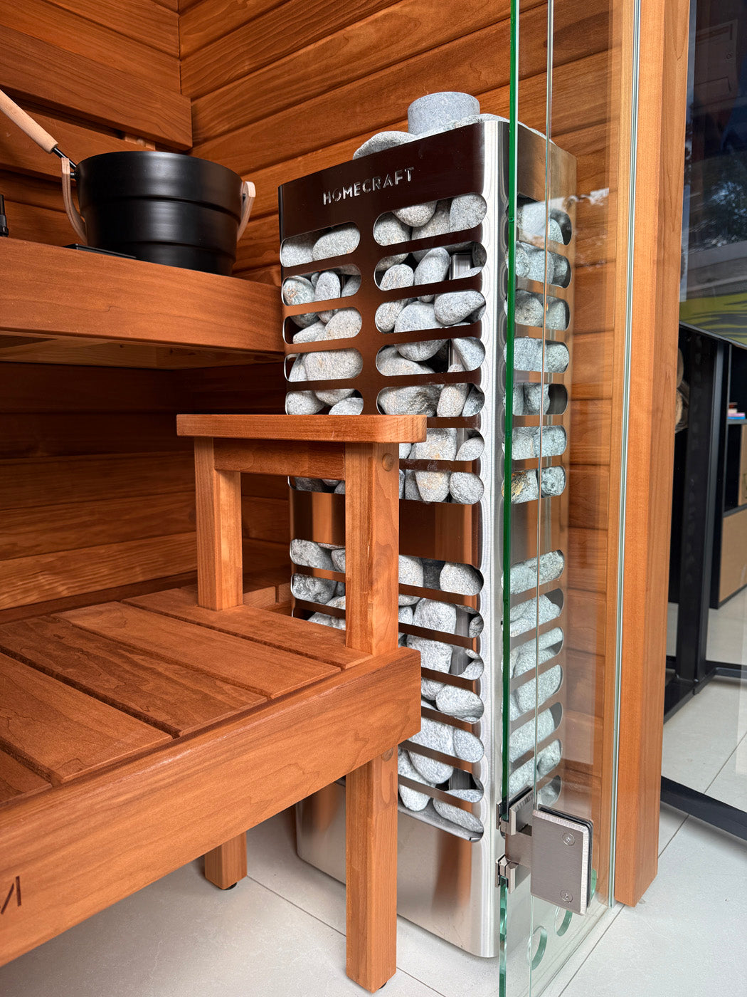 Homecraft Revive Slim heater in a cedar sauna beside a glass wall